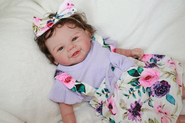 A baby doll wearing a purple dress and a decorative flower headband.